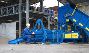 Techniker führt die Wartung Kanalballenpresse an einer ANIS-Kanalballenpresse durch, inklusive Prüfung der mechanischen Komponenten und Sicherheitsvorrichtungen in der Recyclinganlage.